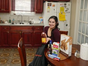 Diana Skakavac unpacks groceries in the kitchen of her grandparents' home in Toronto on Wednesday, Feb.21, 2023. Skakavac is behind the @havecouponswilltravel Instagram account.
