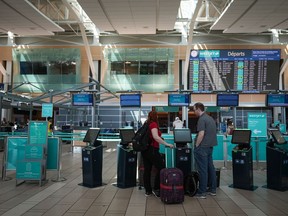 Statistics Canada says the price of airfare fell more than 14 per cent in January versus the same month in 2023. WestJet passengers use a self-service kiosk in the domestic check-in area at Vancouver International Airport, in Richmond, B.C., on Friday, May 19, 2023.