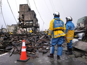 Police officers search victims from debris of damaged and burnt buildings in Wajima, in the Noto peninsula facing the Sea of Japan, northwest of Tokyo, on Jan. 7.