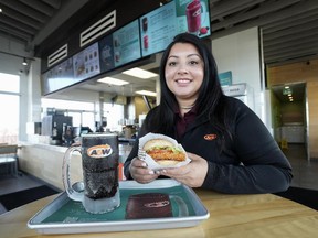 Priya Dhillon, who runs several A&W locations with her family, holding a spicy piri piri potato buddy at an A&W location in Mississauga, Ont.