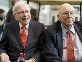 FILE- In this May 3, 2019 file photo, Berkshire Hathaway Chairman and CEO Warren Buffett, left, and Vice Chairman Charlie Munger, briefly chat with reporters before Berkshire Hathaway's annual shareholders meeting. Buffett credited his longtime partner -- the late Charlie Munger -- with being the architect of the Berkshire Hathaway conglomerate he's received the credit for leading and warned shareholders in his annual letter not to listen to Wall Street pundits or financial advisors who urge them to trade often.