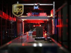 Packages move along a conveyor belt at the United Parcel Service Inc. (UPS) Chicago Area Consolidation Hub (CACH) facility in Hodgkins, Ill.