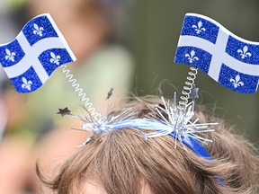 A young child wears Quebec flags on his head