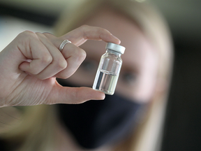 A scientist holds up a vial