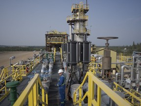 A worker stands on a steam-assisted gravity drainage pad at Cenovus' Sunrise oil facility northeast of Fort McMurray on Thursday, Aug. 31, 2023. Cenovus Energy Inc. reported a fourth-quarter of $743 million, down from $784 million a year earlier, as its revenue also edged lower.