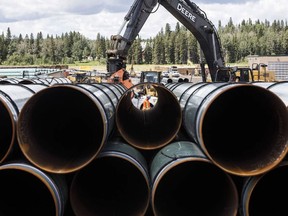 Pipes for the Trans Mountain pipeline expansion are unloaded in Edson, Alta last year.