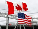 Canadian and American flags fly on the Blue Water Bridge, which crosses Ontario into Michigan.  A strong U.S. economy could lead to higher mortgage rates on the northern side of the border. 

