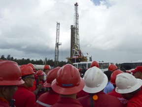 Oil workers gather by an oil well operated by Venezuela's state-owned oil company PDVSA in 2011.