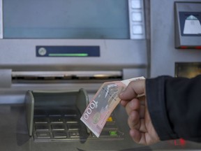A man withdraws Serbian Dinars from a bank cash machine in northern Serb-dominated part of ethnically divided town of Mitrovica, Kosovo, Wednesday, Jan. 31, 2024. The ban on the Serbian currency was to start on Thursday. USA, Great Britain, France, Italy and Germany called Kosovo Prime Minister Albin Kurti to suspend enforcement of a regulation which bans the Serbian currency in Kosovo.