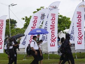 FILE - High school students walk past ExxonMobil flags as they arrive to a job fair at the University of Guyana in Georgetown, Guyana, April 21, 2023. ExxonMobil said on Feb. 7, 2024 that it plans to explore for oil and gas in the Essequibo, a region disputed between Guyana and Venezuela. Guyana awarded the exploration license.