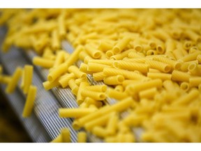 Tabung pasta tortiglioni bergerak di sepanjang konveyor di jalur produksi di dalam pabrik pasta Barilla Holding SpA di Solnechnogorsk, dekat Moskow, Rusia, pada 11 September 2019. Barilla didirikan oleh Pietro Barilla pada tahun 1877 sebagai toko roti kecil di jalan pedagang di pusat kota Parma, sebuah kota dengan gereja-gereja berpilar dan piazza yang ramai hampir di setiap belokan.