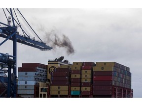 Smoke rises from a container ship's funnels on the dockside at the Port of Felixstowe Ltd. in Felixstowe, U.K., on Thursday, Nov. 19, 2020. The organization responsible for setting global environmental standards for shipping approved rules designed to curb the industry's carbon emissions, triggering criticism that its measures won't do enough to help tackle climate change. Photographer: Chris Ratcliffe/Bloomberg