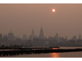 Buildings in the Manhattan skyline shrouded in smoke from Canada wildfires at sunrise on June 7, 2023. Photographer: Yuki Iwamura/Bloomberg