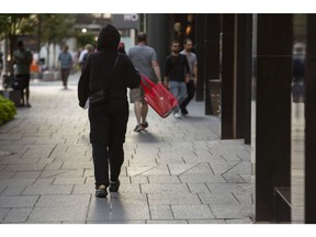 A shopper carries a Lululemon bag in Toronto, Ontario, Canada, on Monday, Aug. 28, 2023. Canadian consumers may be ready to wind down their spending, with retail sales data showing waning momentum at the end of the second quarter. Photographer: Della Rollins/Bloomberg