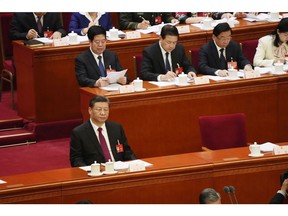 Xi Jinping, China's president, left, listens as Li Qiang, China's premier, not pictured, speaks during the opening of the Second Session of the 14th National People's Congress (NPC) at the Great Hall of the People in Beijing, China, on Tuesday, March 5, 2024. China will set its growth target at around 5% for the year, according to a copy of the government's annual work report seen by Bloomberg News, raising expectations for officials to unleash more stimulus as they try to lift confidence in a slowing economy. Photographer: Qilai Shen/Bloomberg