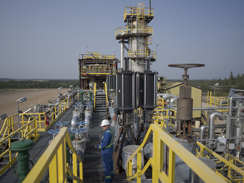 A worker stands on a steam-assisted gravity drainage platform at Cenovus' Sunrise oil facility northeast of Fort McMurray on Thursday, Aug. 31, 2023.