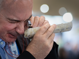 A man examines a piece of metal with a loupe