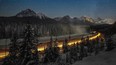 A cargo train passes through the famous Morant's Curve on the Bow River at Banff National park near Lake Louise.