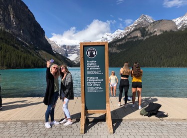 Tourists take photographs at Lake Louise. Traffic jams are common in Banff during the summer tourist high season.