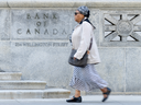 A woman walks past the Bank of Canada building in Ottawa. The Bank of Canada held its key interest rate steady at five per cent on March 6, 2024.