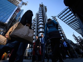 Workers walk past the Lloyds building in London's financial district.