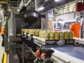 Packages of beer cans move along a conveyor at the Waterloo Brewing Ltd. brewery in Waterloo, Ont.