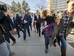 FILE - Chrystina Page, right, holds back Heather De Wolf as she yells at Jon Hallford, left, the owner of Back to Nature Funeral Home, as he leaves with his lawyers following a preliminary hearing, Feb. 8, 2024, outside the El Paso County Judicial Building in Colorado Springs, Colo. Jon Hallford and his wife, Carie Hallford, are each charged with 190 counts of abuse of a corpse, five counts of theft, four counts of money laundering and over 50 counts of forgery, but their criminal case was delayed until June on Thursday, March 21, at the request of defense attorneys.