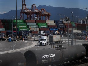 The Vancouver Fraser Port Authority says a record cargo volume rolled through its terminals last year, despite a sputtering global economy and a big drop in container shipments. Transport trucks carry cargo containers at port in Vancouver, on Friday, July 14, 2023.