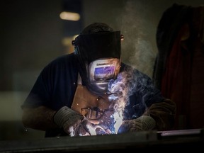 Employees weld the seams of metal doors