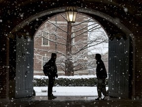 FILE - Wheaton College students stop to chat on the Norton, Mass. campus, Feb. 13, 2024 as snow falls. More than 75 million student loan borrowers have enrolled in the U.S. government's newest repayment plan since it launched in August.