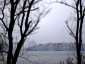 A container ship rests against the wreckage of the Francis Scott Key Bridge on Thursday, March 28, 2024, in Baltimore, Md. After days of searching through murky water for the workers missing after the bridge collapsed, officials are turning their attention Thursday to what promises to be a massive salvage operation.
