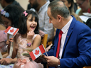 A father and his daughter celebrate after being sworn in as Canadian citizens in Windsor, Ont., in 2020.
