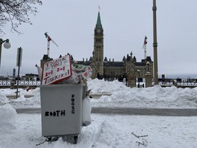 Garbage bins of trucker convoy signs were in front of Parliament Hill after it had been cleared of protesters.