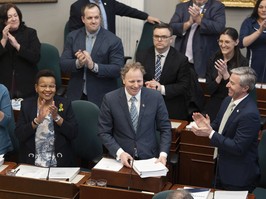 Finance and Treasury Board Minister Allan MacMaster, bottom centre, is applauded by party members while tabling the provincial budget at the Nova Scotia legislature in Halifax.