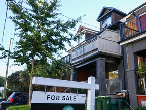 A 'for sale' is sign is displayed in front of a house in the Riverdale area of Toronto.