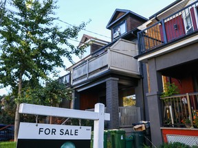 A 'for sale' is sign is displayed in front of a house in the Riverdale area of Toronto.