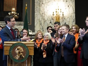 FILE -Washington Attorney General Bob Ferguson introduces Sen. Jamie Pedersen, D-Seattle, second from right, after making remarks Tuesday, April 25, 2023, at the Capitol in Olympia, Wash. A federal judge on Friday, March 8, 2024 rejected a challenge to a Washington state law that cleared the way for lawsuits against the gun industry in certain cases. The measure was one of three bills signed by Democratic Gov. Jay Inslee last year seeking to address gun violence.