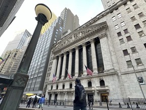 People pass the New York Stock Exchange on Wednesday, March 13, 2024, in New York. Global shares are mixed in muted trading as optimism set off by a record rally on Wall Street gradually ran out of momentum.