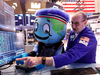 Harlem Globetrotter mascot Globey watches as trader Pete Giacchi works on the floor of the New York Stock Exchange