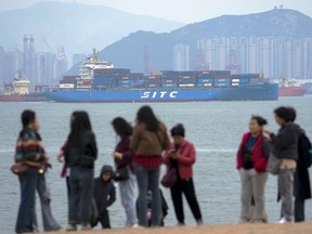 File - A container ship passes tourists in Xiamen in southeast China's Fujian province on Dec. 26, 2023. China's exports and imports for the January-February period beat estimates, an indication that demand may be improving as Beijing attempts to boost economic recovery, according to customs data released Thursday, March 7, 2024.
