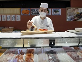 FILE - A sushi chef prepares a plate at the Toyosu Market Monday, Jan. 29, 2024, in Tokyo. Japan's economy managed to grow in the fourth quarter of last year, averting a recession, according to revised government data released Monday, March 11, 2024 that had previously shown a contraction.