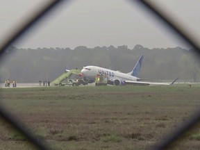 Passengers are evacuated from a United flight at George Bush International Airport, Friday, March 8, 2024 in Houston. Passengers had to be evacuated from the plane after it rolled off a runway and got stuck in the grass. (KTRK via AP)