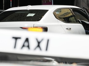 An Uber vehicle stops across the road from a taxi rank in Sydney, Monday, March 18, 2024. Global rideshare giant Uber will pay 272 million Australian dollars ($178 million) to settle a long-running dispute with Australian taxi and hire car drivers who lost out when the company entered the Australian market.