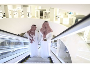 Attendees stand on an escalator as they move through the interior of the King Abdulaziz Center for World Culture during a tour of the project in Dhahran, Saudi Arabia, on Friday, Nov. 25, 2016. When completed, the project designed for the Saudi Arabian Oil Co. (Aramco) will contain diverse cultural facilities, including an auditorium, cinema, library, exhibition hall, museum and archive. Photographer: Simon Dawson/Bloomberg