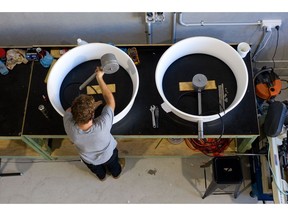 An employee mounts the center body to the diffuser while manufacturing a Hyland 920 small wind turbine at the Diffuse Energy factory in Taylors Beach, New South Wales, Australia, on Thursday, March 25, 2021. Even as the largest wind companies build ever-bigger turbines to power a shift away from fossil fuels, startups in Australia and the U.K. also see potential in thinking small. Less than a meter (3.3 feet) wide and lighter than a pickup truck tire, the equipment can help replace the use of diesel as a power source, and can also be deployed at isolated locations like remote mines or farms. Photographer: Brendon Thorne/Bloomberg