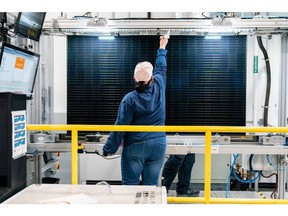 A quality control worker checks a solar panel at a solar cell and module manufacturing facility in Dalton, Georgia.