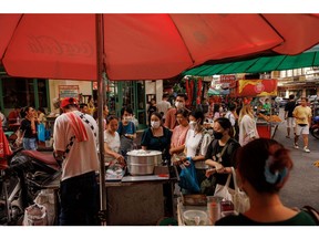 Customers wait for their order at a street food stall in Bangkok, Thailand, on Sunday, Dec. 3, 2023. While Thai tourism has rebounded and exports have started to recover, enabling the baht to become among the best performers in the region this month, foreign guests are shelling out about 25% less now compared to pre-Covid, and staying for shorter periods. Photographer: Andre Malerba/Bloomberg