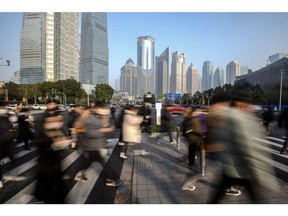 Pedestrians cross a road in Pudong's Lujiazui Financial District in Shanghai, China, on Tuesday, Jan. 9, 2024.  Photographer: Qilai Shen/Bloomberg