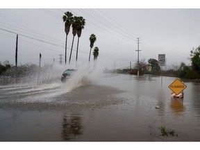 A vehicle drives through a flooded street during a storm in Whittier, California, US, on Tuesday, Feb. 6, 2024. The risk of flash flooding and landslides persists for 21 million people across California as rains from a deadly atmospheric river keep falling throughout the day.