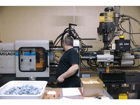 A worker operates an injection molding machine at a manufacturing facility in Kingston, New York.